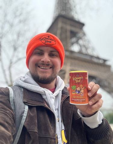 Person holding LeJeune's Best can with the Eiffel Tower in the background.