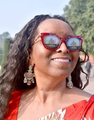 Close-up of sunglasses reflecting the Taj Mahal.
