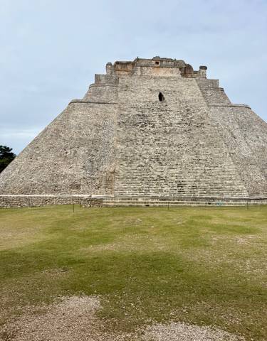 Ancient stone pyramid with a staircase leading to the top.