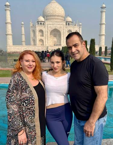 People posing in front of the Taj Mahal.