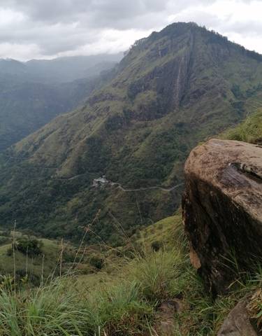 Overlook of a lush mountainous landscape with a path leading through.