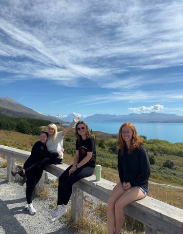 People enjoying a scenic view of a lake and mountains.