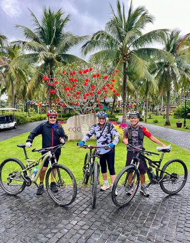Three cyclists with decorated bikes in a park