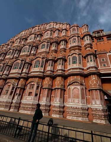 Hawa Mahal with its intricate facade and people walking past.