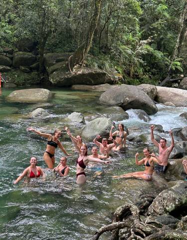 People enjoying a swim in a natural rocky pool.