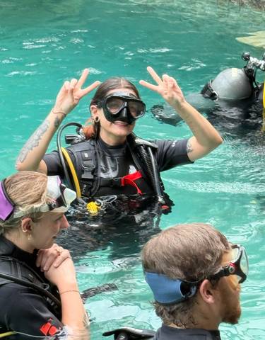Person in scuba gear in a pool with others