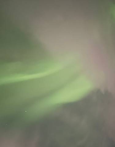 Aurora lights in the night sky with stars visible.