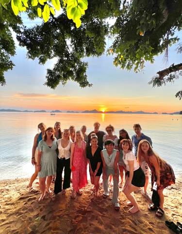 Group of people posing at sunset on the beach.
