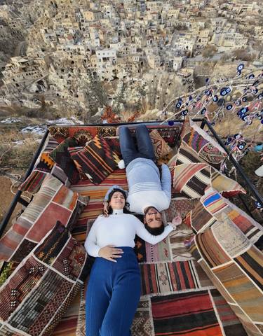 Two people lying on cushions with colorful patterns.