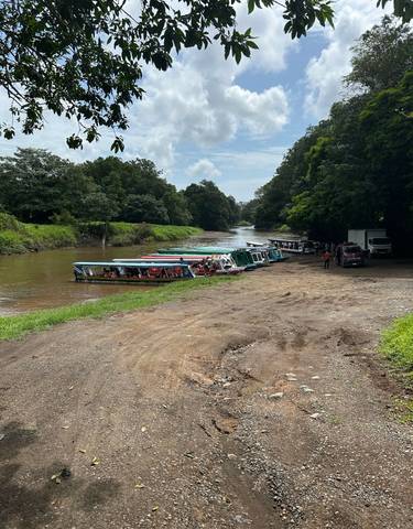 Boats lined up along a riverbank with people boarding.
