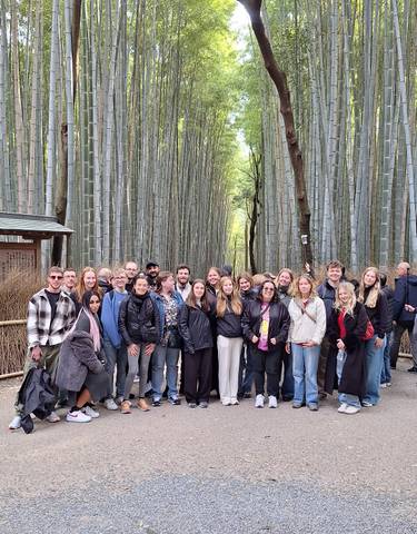 Group of people posing in a bamboo forest.