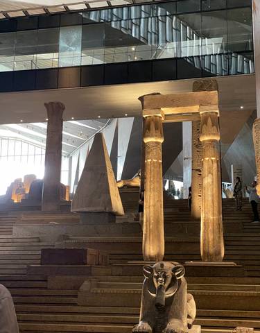 Interior of a museum displaying ancient Egyptian artifacts and columns.