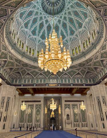 Intricate mosque interior with large chandelier.