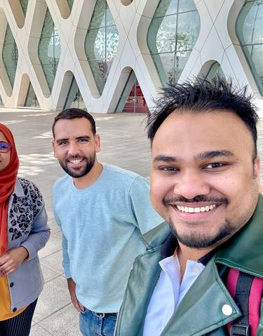 Two smiling people taking a selfie outdoors.