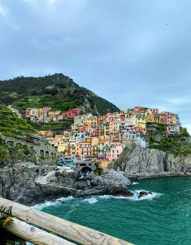 Colorful hillside village with terraced buildings and rocky cliffs.