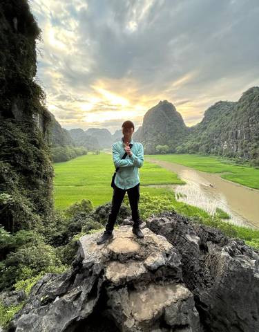 Man standing with scenic view of mountains and a river.