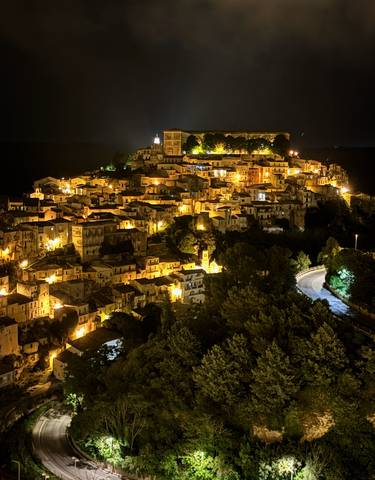 Illuminated town at night from a high vantage point.