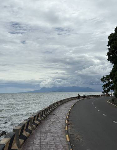 A scenic coastal road with mountains in the background.
