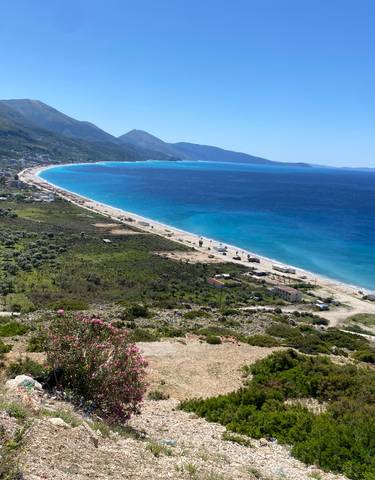 A panoramic view of a coastal landscape with mountains.