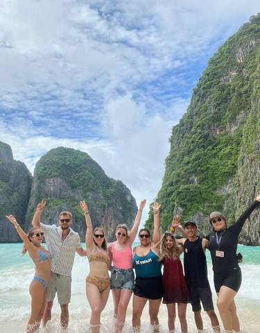Group of people posing with scenic cliffs in the background.