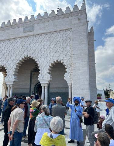 Group of tourists outside a mosque with intricate architecture.