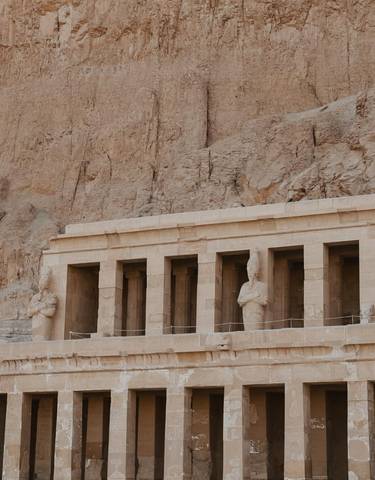 Ruins of ancient Egyptian temple with statues.