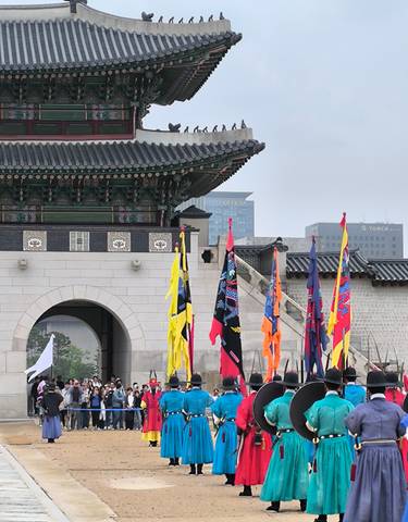 Traditional Korean building with flags displayed outside.