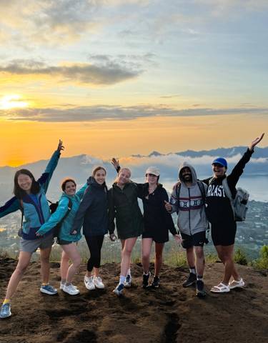 Group of friends celebrating with a sunrise view.