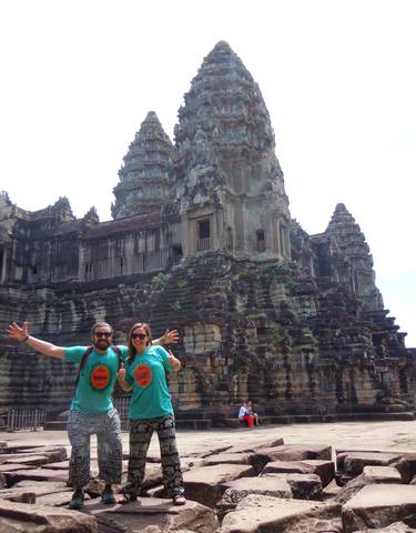 Two people posing in front of ancient ruins.