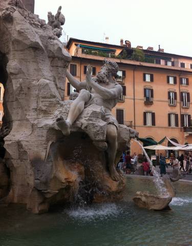 Famous fountain with statues in a busy square.