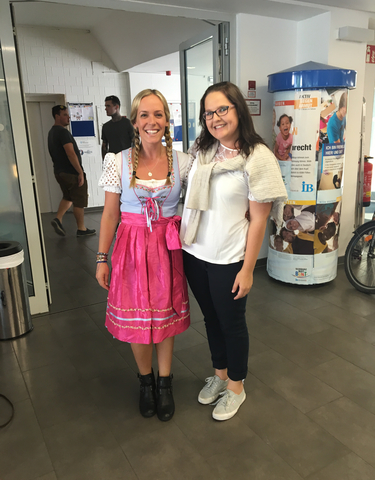 Two women posing in traditional attire indoors.