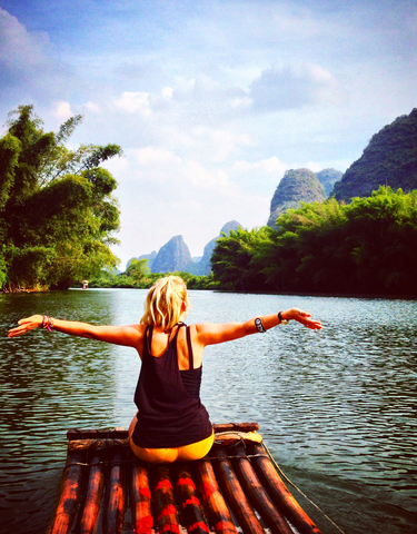 Person enjoying a river view with karst mountains.