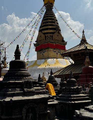 A Buddhist stupa with prayer flags against a blue sky