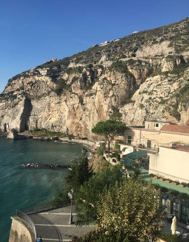 Seaside houses at the base of rocky cliffs.