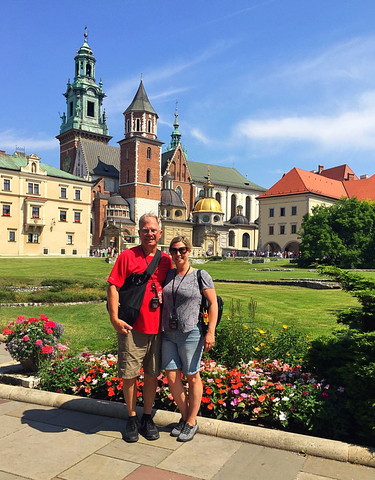 Tourists in front of a castle with a garden.