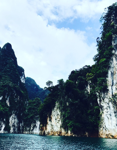 View of large, lush green mountains under a blue sky.