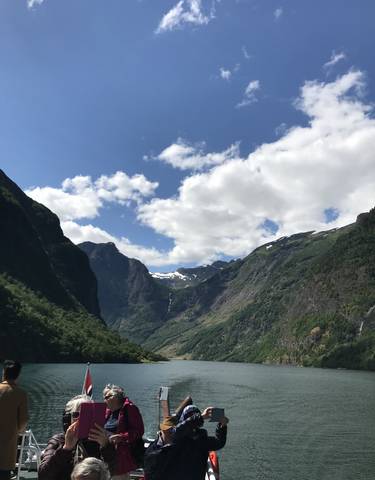 Mountain valley view with partly cloudy sky.