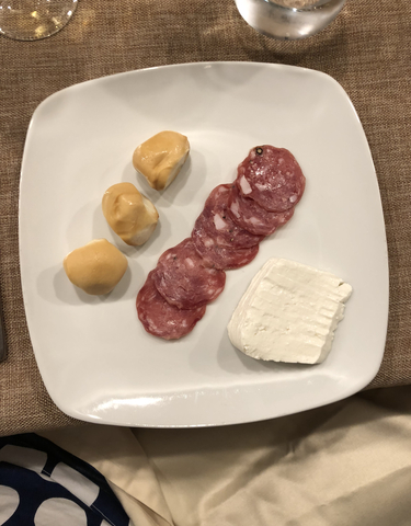 Dish with cheese, salami, and balls of mozzarella.