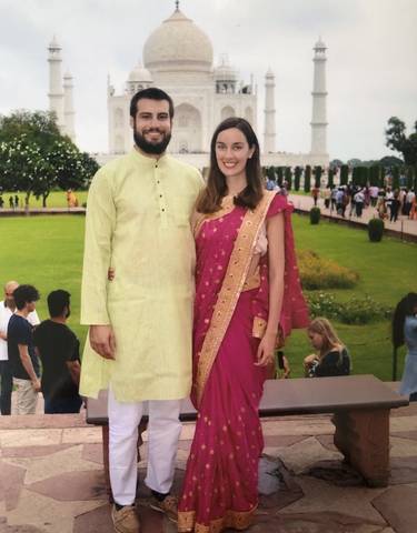 Couple posing in traditional attire in a garden.