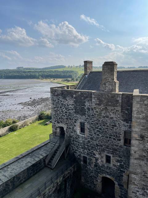       Upside-down image of a stone building by a river.
  