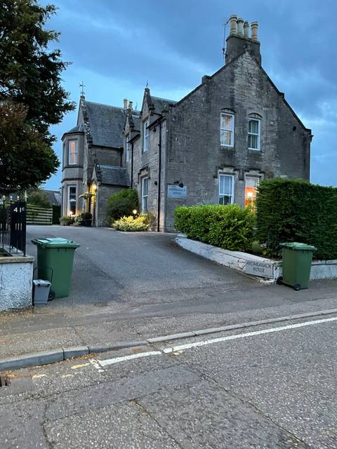       Upside-down image of a street with houses and a green bin.
  