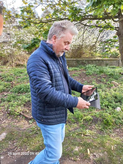 Person using a tablet while walking on a path.