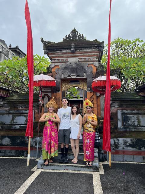       Group of people in traditional clothing in front of decorated entrance.
  