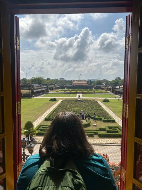       A woman looking over a historic site under a cloudy sky.
  