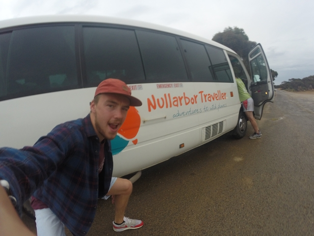       Person taking a selfie with a travel van featuring Nullarbor Traveller branding.
  