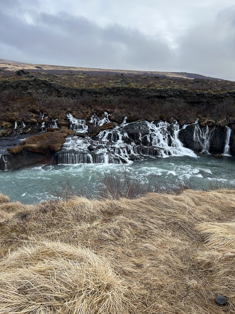       Picturesque waterfall flowing over layered rock formations.
  