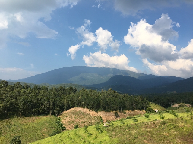 Mountainous landscape with blue sky and white clouds.