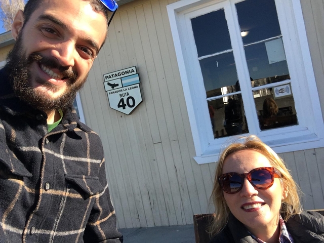       Two people with a sign for Patagonia and Ruta 40 in the background.
  