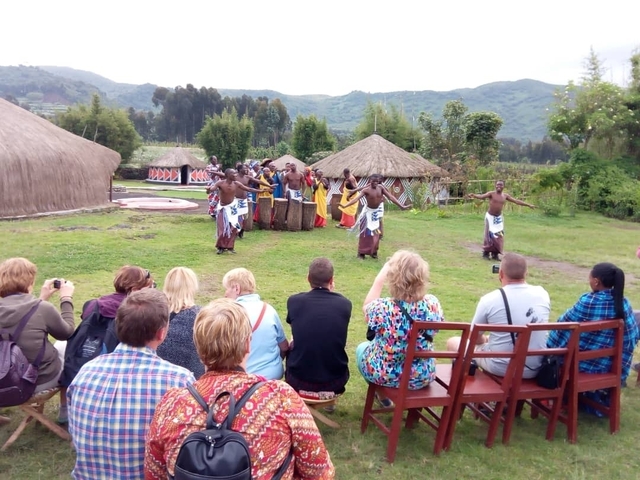       Cultural performance with dancers and spectators in an outdoor setting.
  