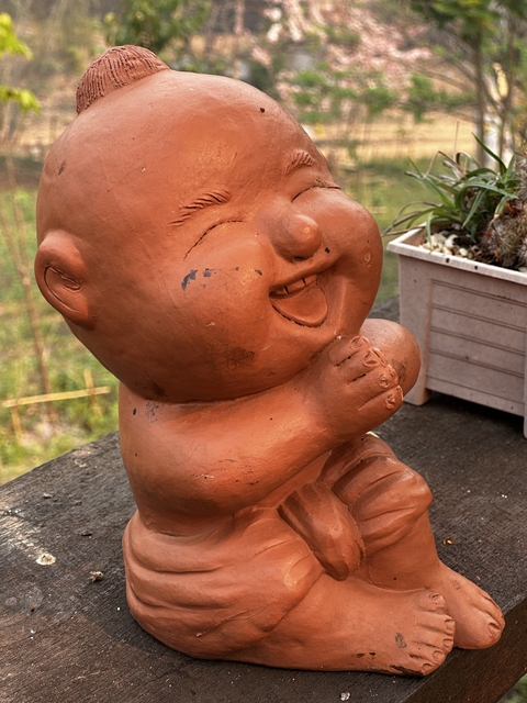 Clay sculpture of a laughing baby.